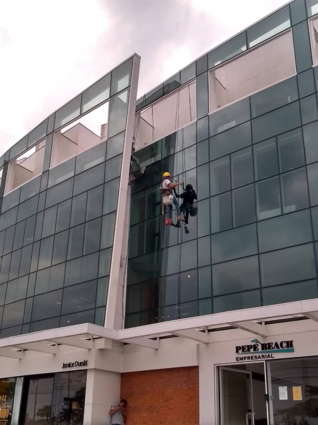 Trabalho em fachada comercial de vidro por rapel